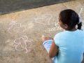 Participante del taller dibujando con tiza en la Plaza de Bayamón