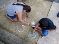 Participante del taller dibujando con tiza en la Plaza de Bayamón