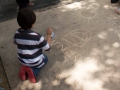 Participante del taller dibujando con tiza en la Plaza de Bayamón