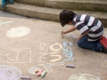 Participante del taller dibujando con tiza en la Plaza de Bayamón