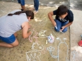 Participantes del taller dibujando con tiza en la Plaza de Bayamón