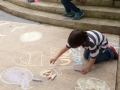 Participantes del taller dibujando con tiza en la Plaza de Bayamón