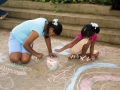 Participantes del taller dibujando con tiza en la Plaza de Bayamón